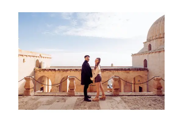 Casal apaixonado assistindo ao pôr do sol em um destino paradisíaco, representando viagens românticas e experiências inesquecíveis