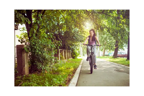 Viajante explorando uma trilha ecológica rodeada de natureza, representando práticas de turismo sustentável e econômico