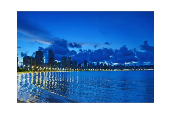 Vista aérea noturna de Balneário Camboriú com edifícios iluminados e a FG Big Wheel, representando o turismo de luxo na cidade