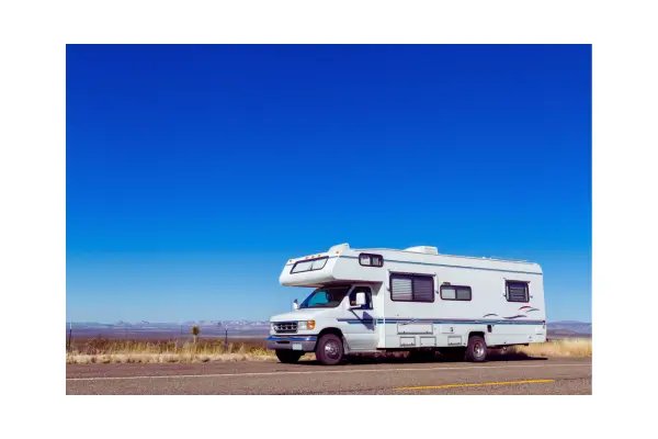 Motorhome com painéis solares estacionado em cenário natural, representando energia solar para viagens sustentáveis