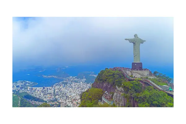 Vista panorâmica do Rio de Janeiro mostrando o Cristo Redentor e o Pão de Açúcar em um dia ensolarado