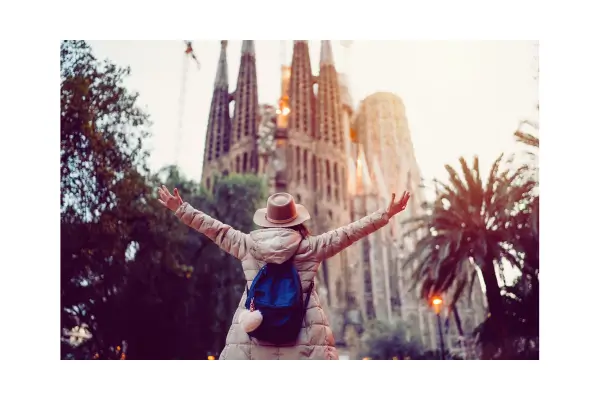 Viajante com mochila pequena em frente à Catedral de Sevilha, mostrando viagem econômica
