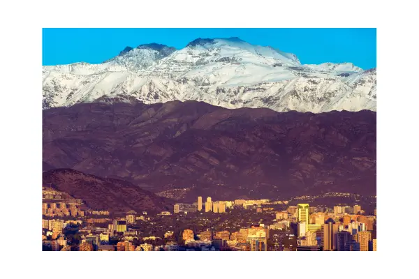 Vista panorâmica de Santiago, Chile, com a Cordilheira dos Andes ao fundo e edifícios urbanos em primeiro plano