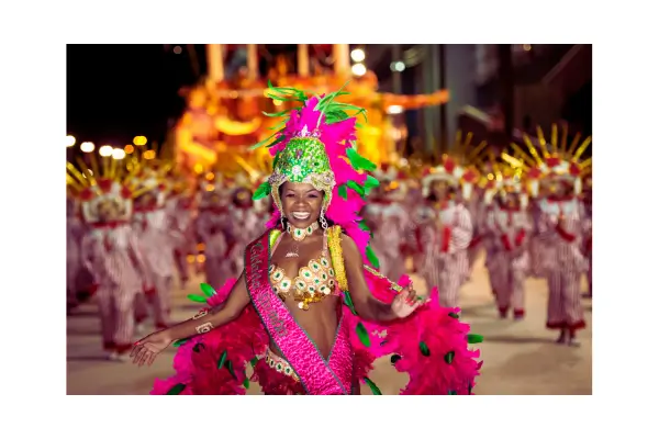 Pessoas fantasiadas curtindo o Carnaval do Rio 2026 no Sambódromo, com confetes e alegria, ilustrando dicas de planejamento de viagem.