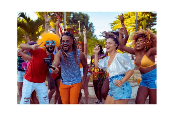Foliões curtindo o Carnaval 2026 no Rio de Janeiro com fantasias coloridas e o Cristo Redentor ao fundo