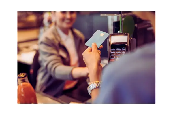 Viajante pagando compras no exterior com cartão de crédito em moeda local